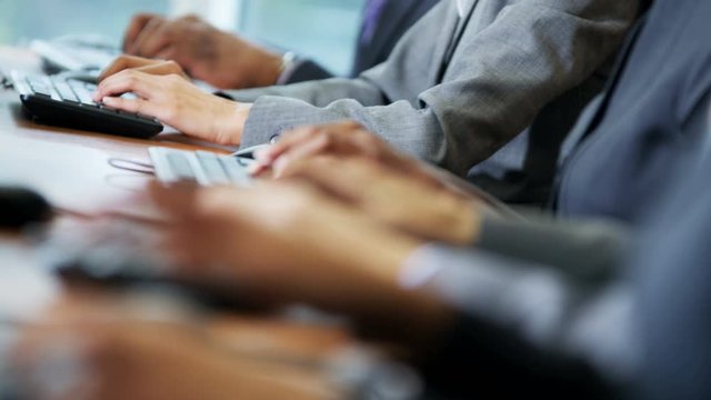 Hands of multi ethnic IT team working in technical business support center 