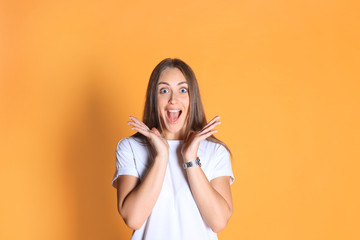 Obraz premium Young woman in casual clothing wondering and screaming isolated over yellow background.
