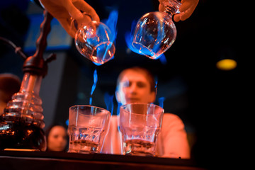Bartender makes hot cocktail sambuca
