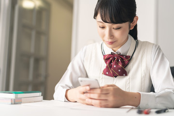 スマホを見る女子高生