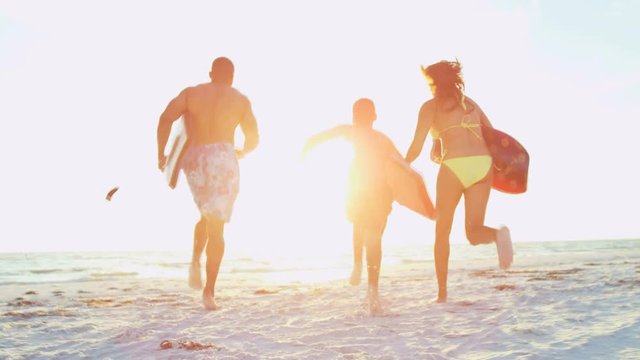 Attractive African American family in swimsuits running with surfboards on the beach RED EPIC