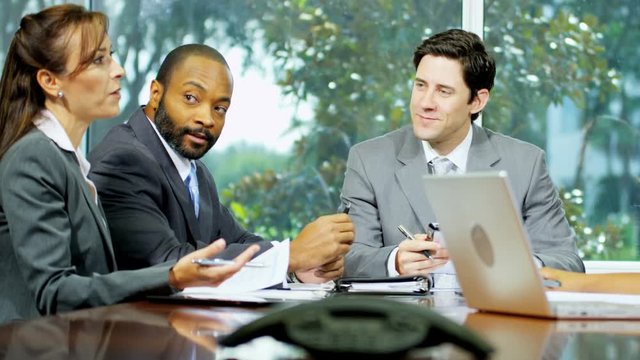 Professional Caucasian American businessman in meeting leading meeting multi ethnic business consultancy team 