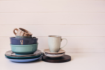 natural rustic handmade kitchenware on wooden background. Ceramic dished and cups in neutral tones, scandinavian style.