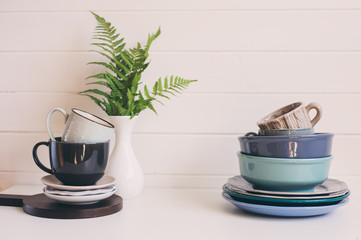 natural rustic handmade kitchenware on wooden background. Ceramic dished and cups in neutral tones, scandinavian style.