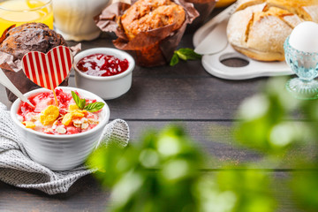 Valentine's day concept. Breakfast served with muffins,  juice, fresh bread and parfait on a dark wooden table.