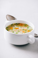 White bowl of homemade vegetable soup on concrete background