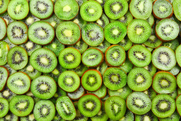 Fototapeta na wymiar Top view of heap of sliced kiwi as textured background.