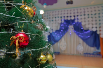 A Christmas red and gold ball hangs on the background of a clock. It's time for a new year....