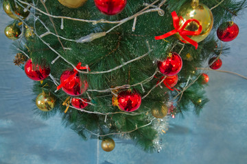 A Christmas ball hangs on the background of a clock. It's time for a new year. Multicolored glare...