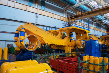 Fototapeta premium Line, conveyor for the production of large yellow trucks, mining trucks.