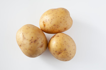 Three potatoes on a white background. Isolated