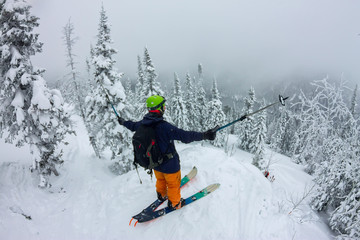 Fototapeta na wymiar Man splitboard freerider standing at top of ridge. Ski touring in mountains, winter freeride extreme sport