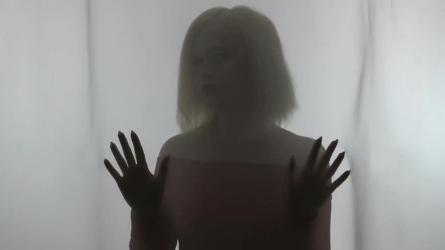 Silhouette of beautiful girl, hands touches fabric.