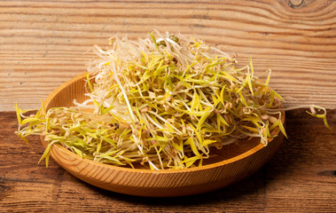 sprouts of mung beans on wooden background close up