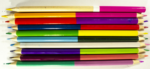 Fototapeta premium Pencils for drawing on paper of different colors lie on a white drawing paper.