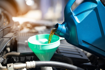 Close up of Pouring fresh oil to car engine in auto repair service, Change oil