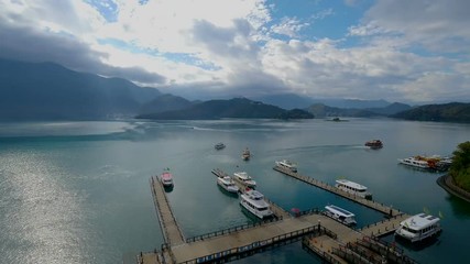 Timelapse landscape of boats in the harbor with cloud movement and sunlight in the morning at Sun Moon Lake, Shuishe Pier in Nantou, Taiwan
