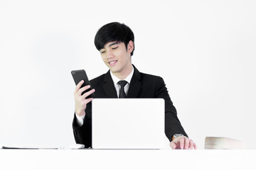 Asian manager businessman sitting at desk and using with phone, isolated on white background.