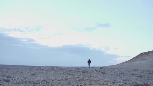 Young woman walk alone in a desert afternoon scenery