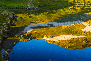 mountain slope reflected in a small calm  lake
