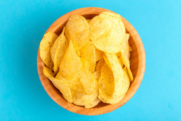 Tasty crispy potato chips in wooden bowl