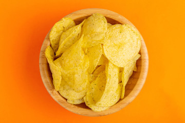Tasty crispy potato chips in wooden bowl