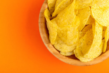Tasty crispy potato chips in wooden bowl
