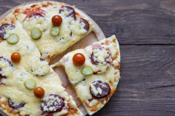homemade traditional pepperoni pizza with salami and cheese, cherry tomatoes on top