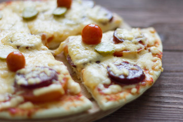 homemade traditional pepperoni pizza with salami and cheese, cherry tomatoes on top
