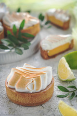 Obraz na płótnie Canvas Fresh lemon tartlets with meringue on white background, close-up. wedding dessert, decorated