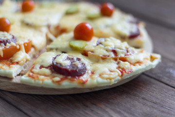 homemade traditional pepperoni pizza with salami and cheese, cherry tomatoes on top