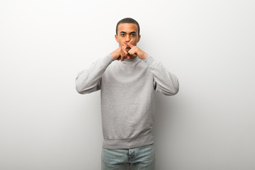 African american man on white wall background showing a sign of silence gesture