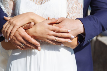 newlyweds hold each other's hands with golden rings