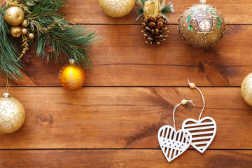 Happy new 2019 year decorations on brown wooden background table, xmas balls baubles and two hearts on merry Christmas tree, winter holidays celebration greeting card, top view, copy space