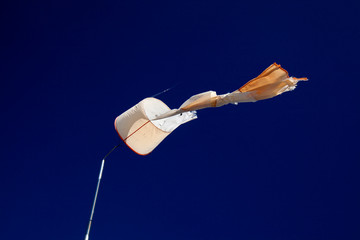 torn windsock against dark blue sky