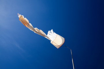 torn windsock against dark blue sky
