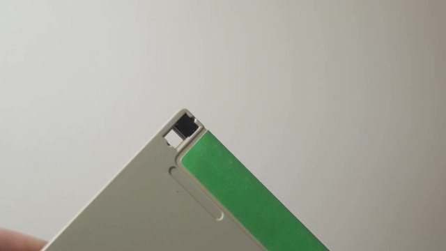 Adjusting the write-protect lock tab on a 3.5 inch floppy disk