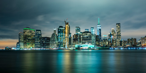 Obraz premium Panoramę Manhattanu nocą z Brooklyn Bridge Park. Nowy Jork, USA. Budynki biurowe i drapacze chmur na Dolnym Manhattanie (Downtown Manhattan).