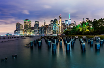 Fototapeta na wymiar Manhattan panoramic skyline at night from Brooklyn Bridge Park. New York City, USA. Office buildings and skyscrapers at Lower Manhattan (Downtown Manhattan)..