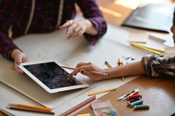 Two creative fashion designers looking at sketch in atelier.