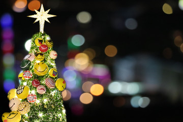 Fototapeta na wymiar Christmas tree and back blur light of city night sky