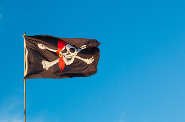 pirate flag with skull and crossbones and blue sky