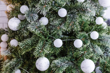 White decorative ball on the christmas tree on glitter bokeh background with blurred snow. Merry christmas card. Winter xmas theme. Happy New Year. Snowing.