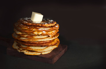A stack of bright delicious flavored pancakes on a black background with space for text.