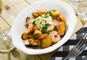Stewed slices of potato with seafood