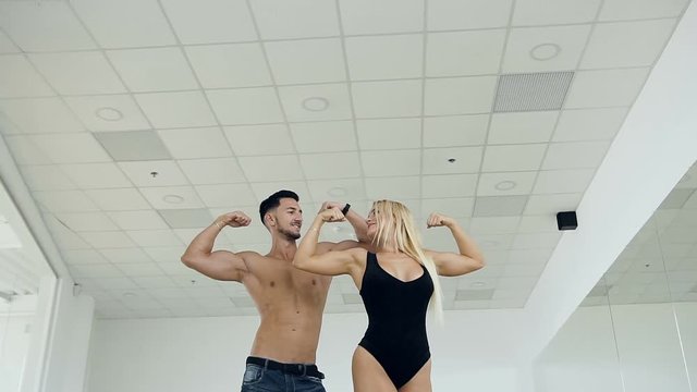 Beatiful caucasian couple man and woman possing on the camera on the studio background.