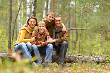 Portrait of family of four resting in autumn forest