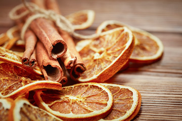dry citrus fruits, cinnamon sticks and anise on wooden background