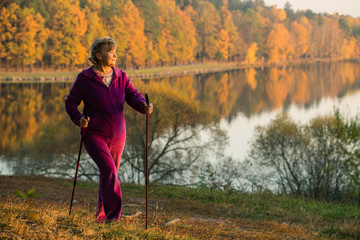 woman Nordic walking with sticks in the countryside