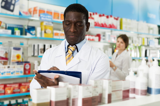 Pharmacist Taking Inventory Of Medicines